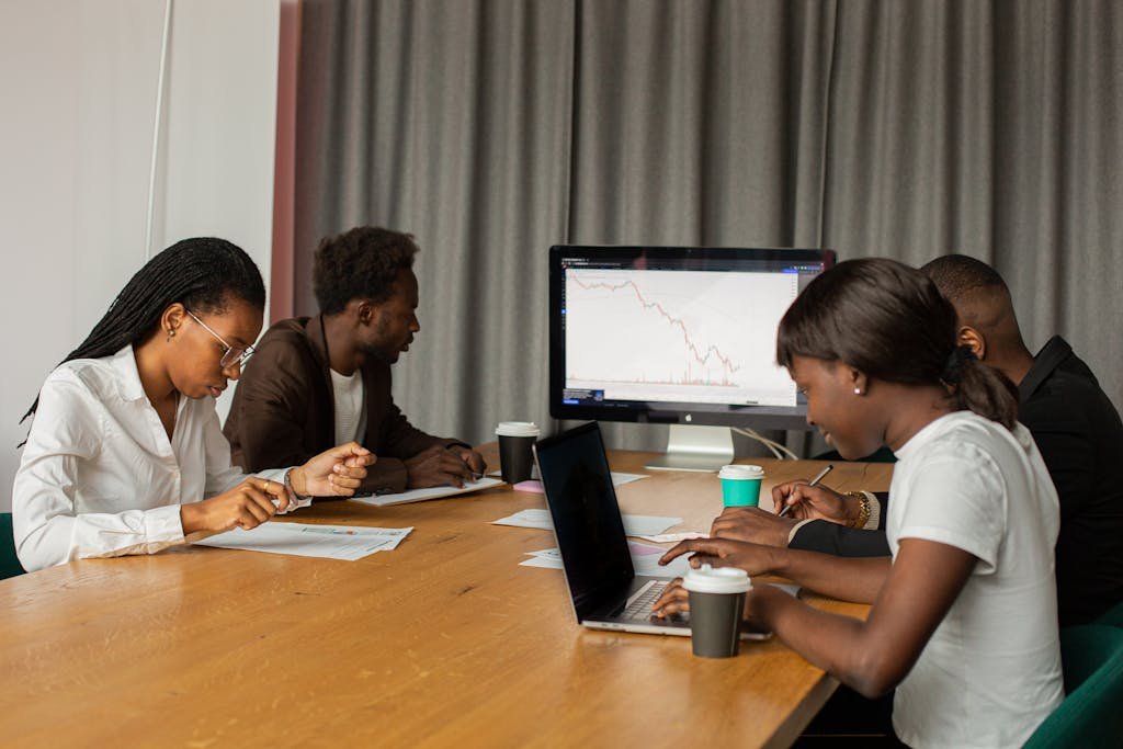 A diverse group of professionals focused on analyzing market data during an office meeting.